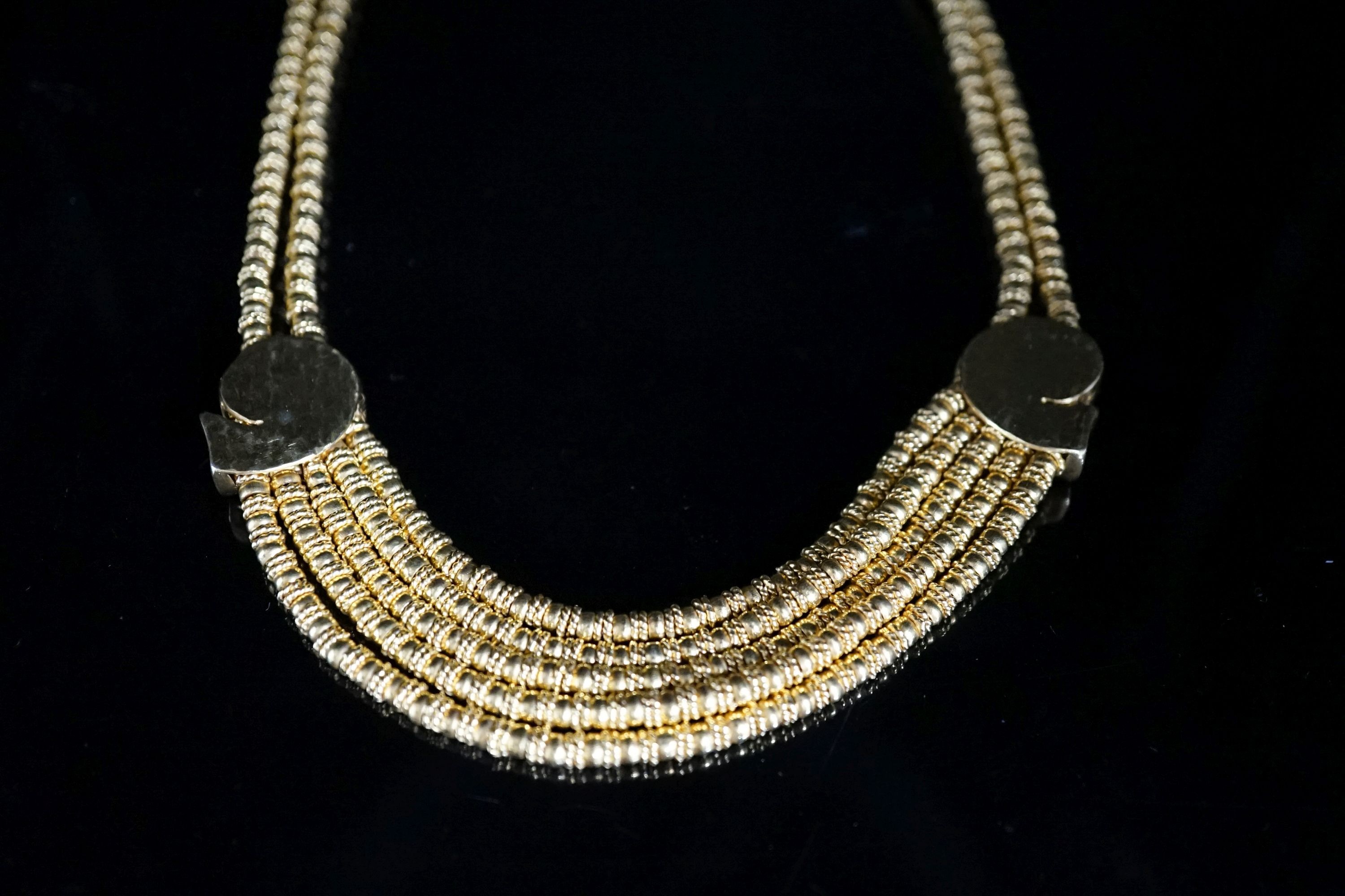 Ilias Lalaounis: a 750 yellow metal multi strand necklace, with shell motifs, 40cm, 146.3 grams, signed.
